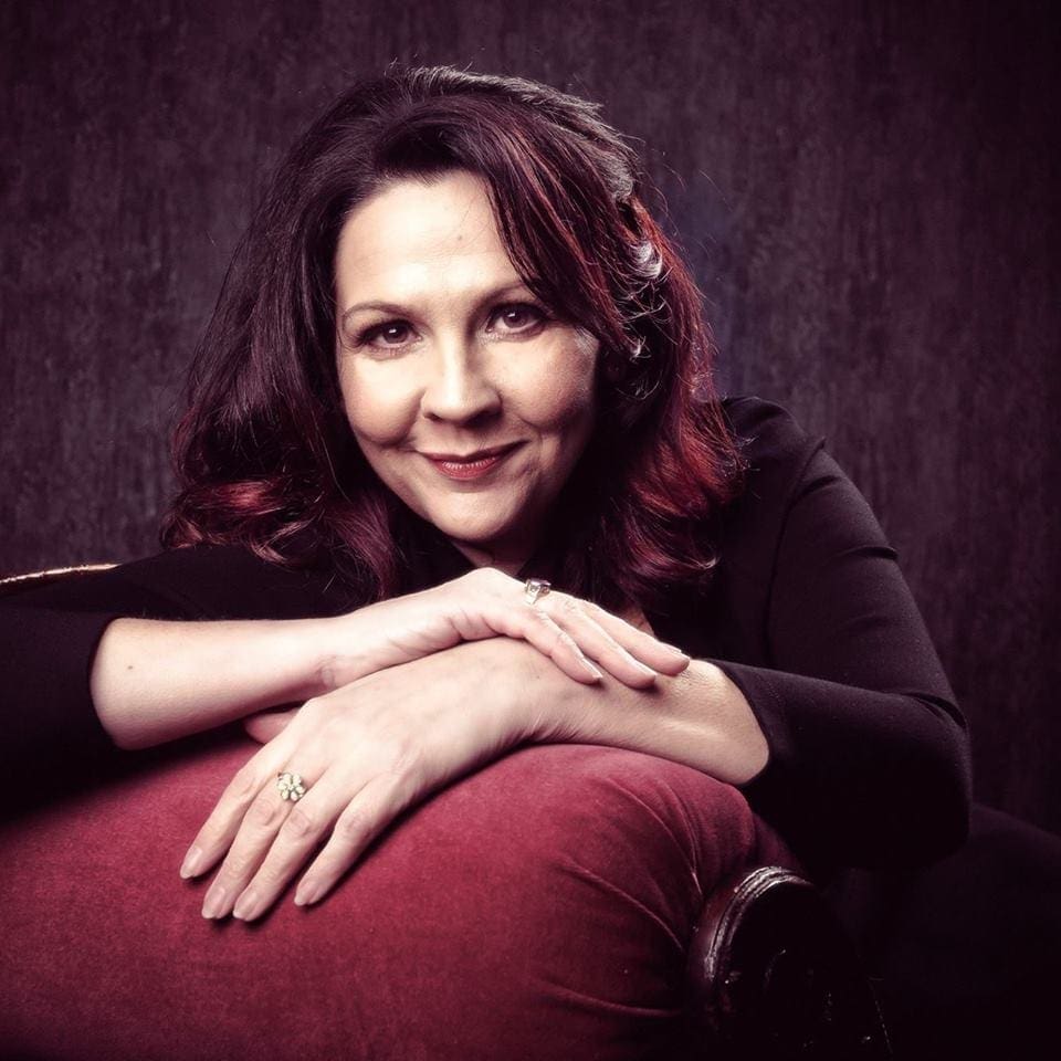 a woman smiling with her arms crossed